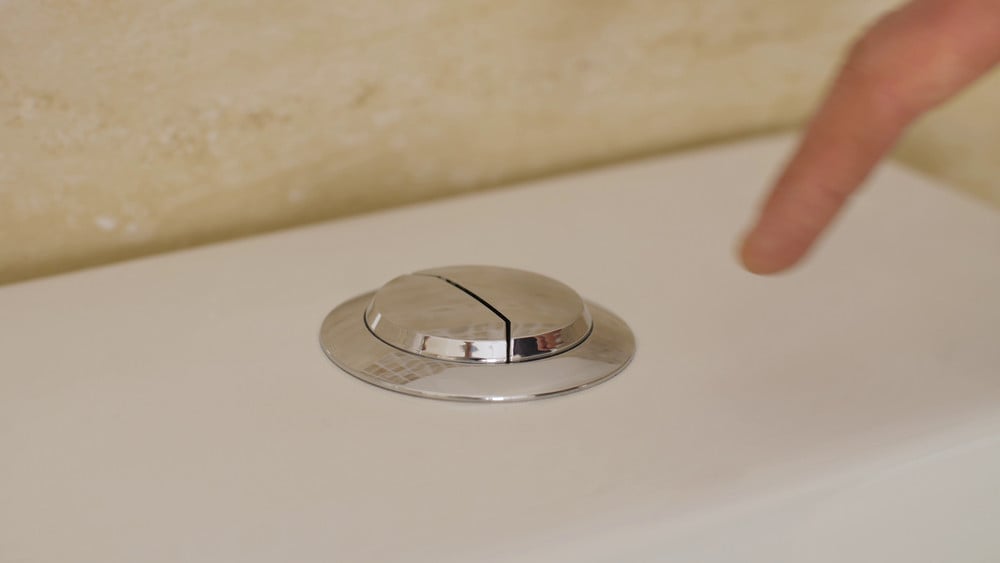 Close-up of toilet flush buttons symbolizing the importance of regular septic tank pumping and system maintenance.